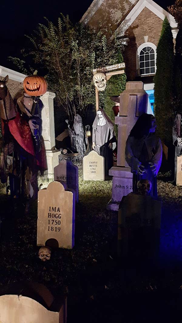Night Side View of Halloween Graveyard Skull Orchard Cemetery with Tombstones, Tree and Spirit