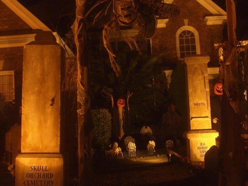 Night View of Halloween Graveyard Entrance Bat Skeleton Skull Orchard Cemetery and Scarecrow