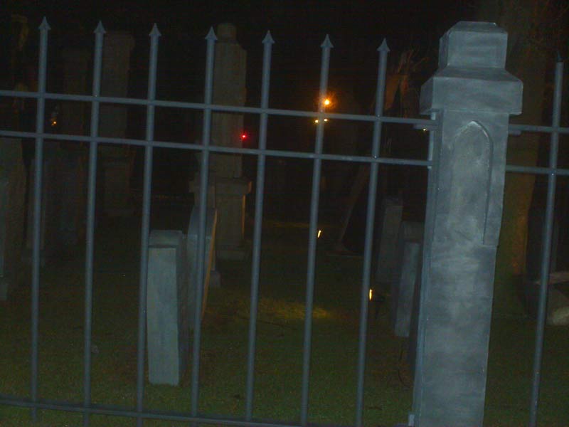 Night View of Halloween Graveyard Entrance Bat Skeleton Skull Orchard Cemetery and Scarecrow