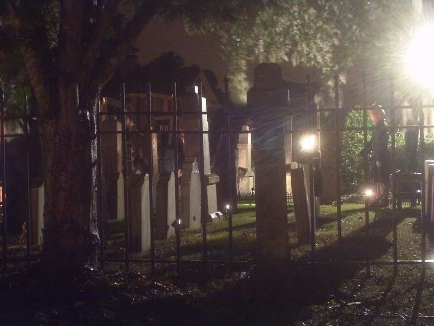 Night Side View of Halloween Graveyard Skull Orchard Cemetery with Tombstones, Tree and Spirit