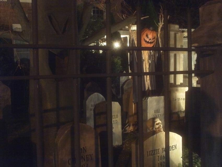 Night Side View of Halloween Graveyard Skull Orchard Cemetery with Tombstones and Tree
