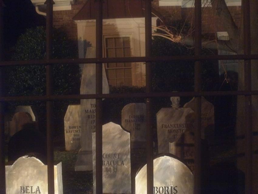 Night Side View of Halloween Graveyard Skull Orchard Cemetery with Tombstones and Tree